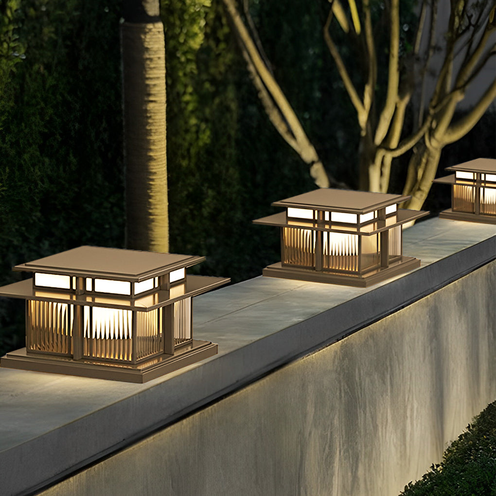 Square outdoor pillar lights mounted along a concrete wall for contemporary landscape lighting.