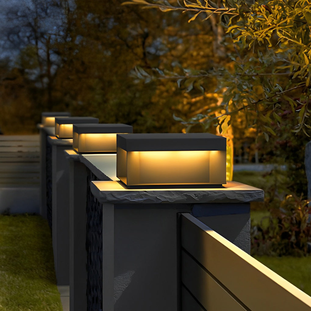 Square solar deck lights mounted on modern fence posts illuminating garden boundary area.