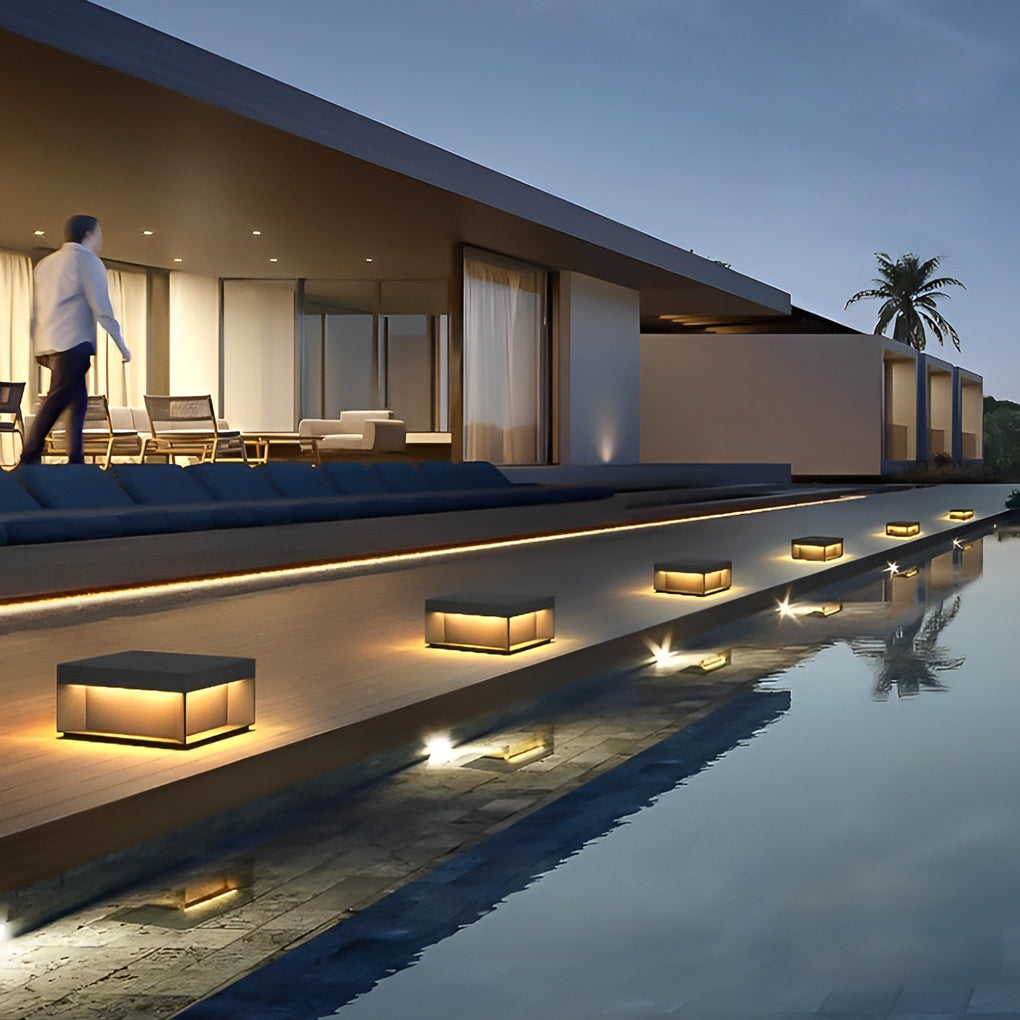Square solar deck lights used along poolside deck creating modern outdoor accent lighting.