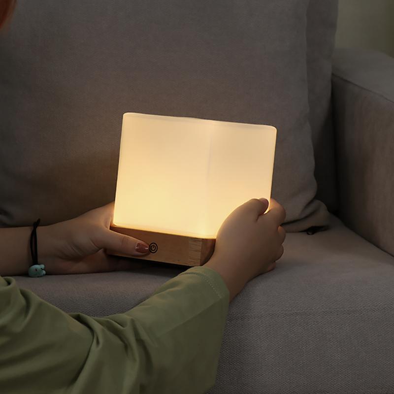 Square wood lamp with a touch control, providing soft illumination.