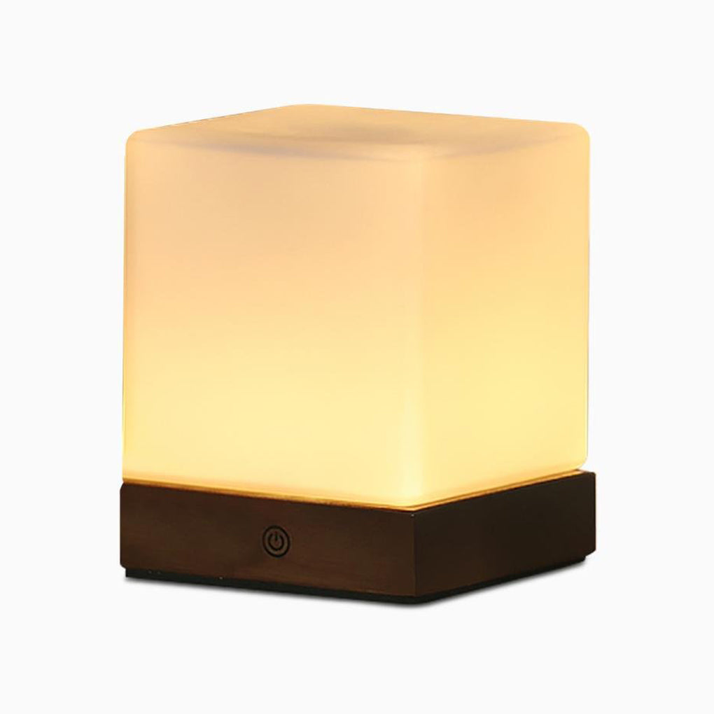 Square wood lamp with a warm light, showcasing its wooden base.