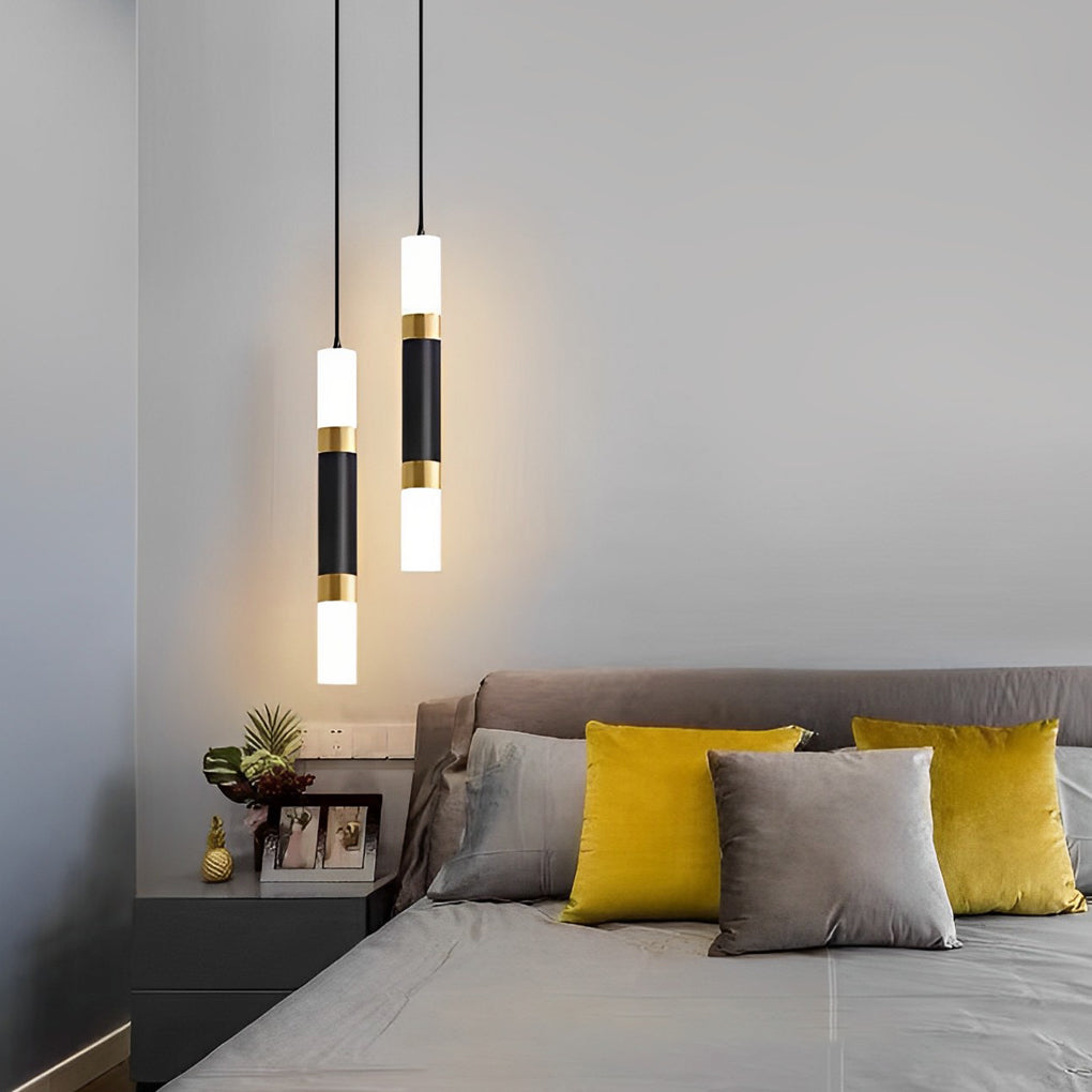Staggered pair of black LED cylinder pendant lights used as bedside lamps in a modern bedroom.