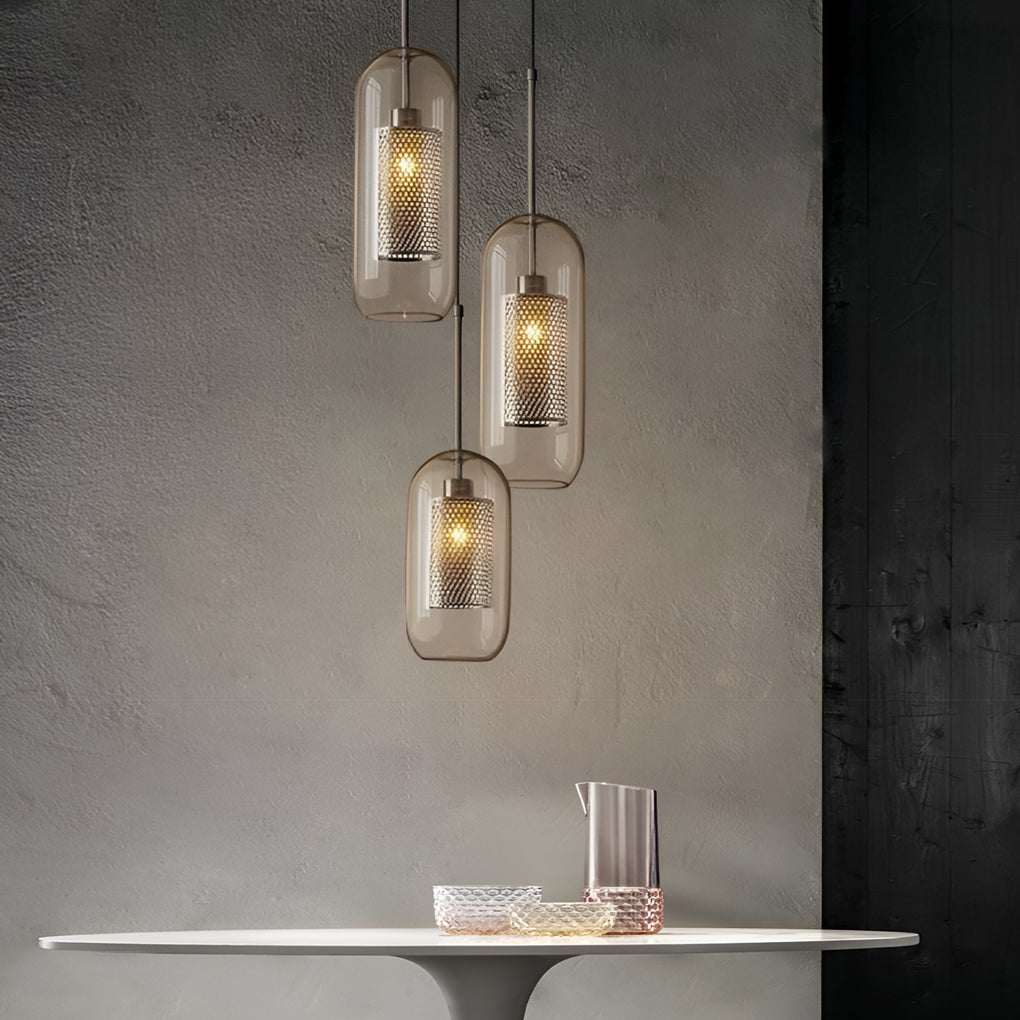 Staggered capsule Clear Glass Globe Pendant trio against a textured grey concrete wall.