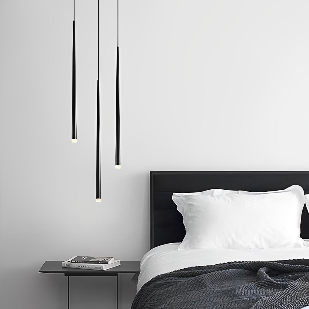 Staggered Slim Black Pendant Light trio over a black bedside nightstand in a modern bedroom.
