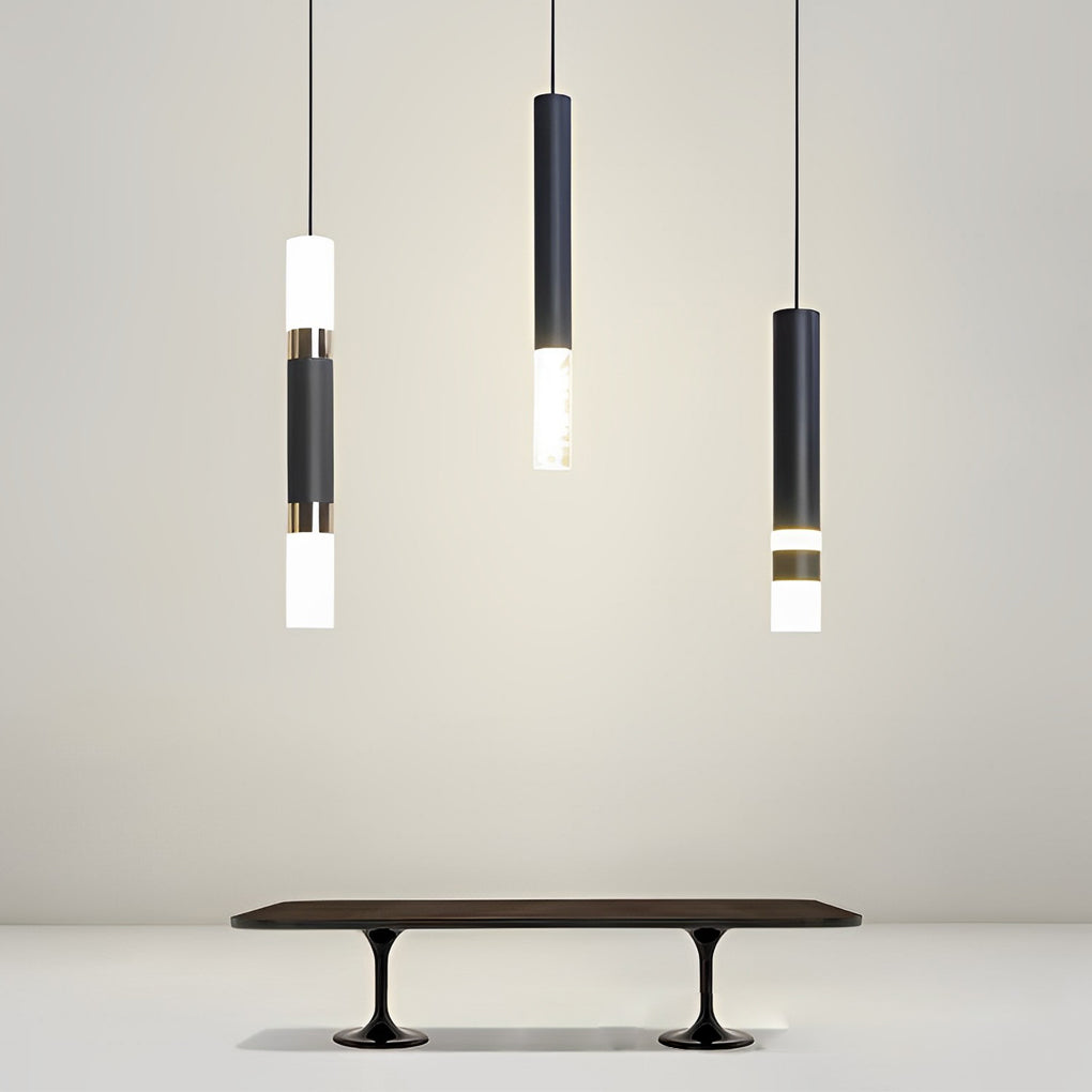 Trio of staggered black LED cylinder pendant lights hanging over a modern black dining table.