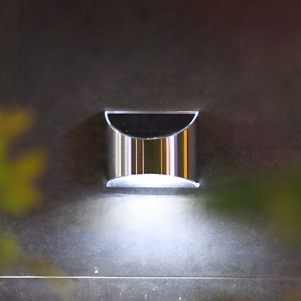 Stainless steel wall lamp with a modern design, illuminating a pathway with bright white light.