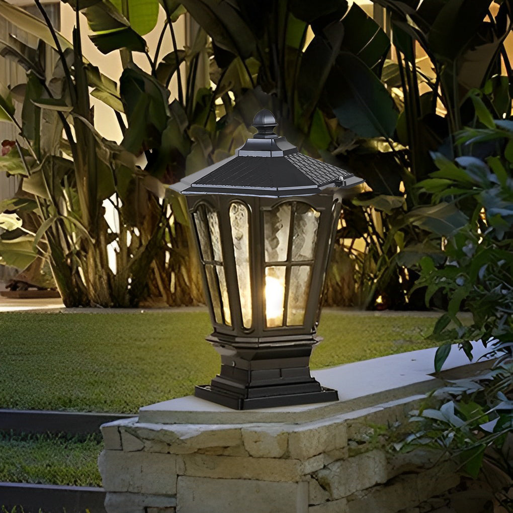 Classic black stone pillar light fixture illuminating landscaped garden wall with soft ambient lighting.