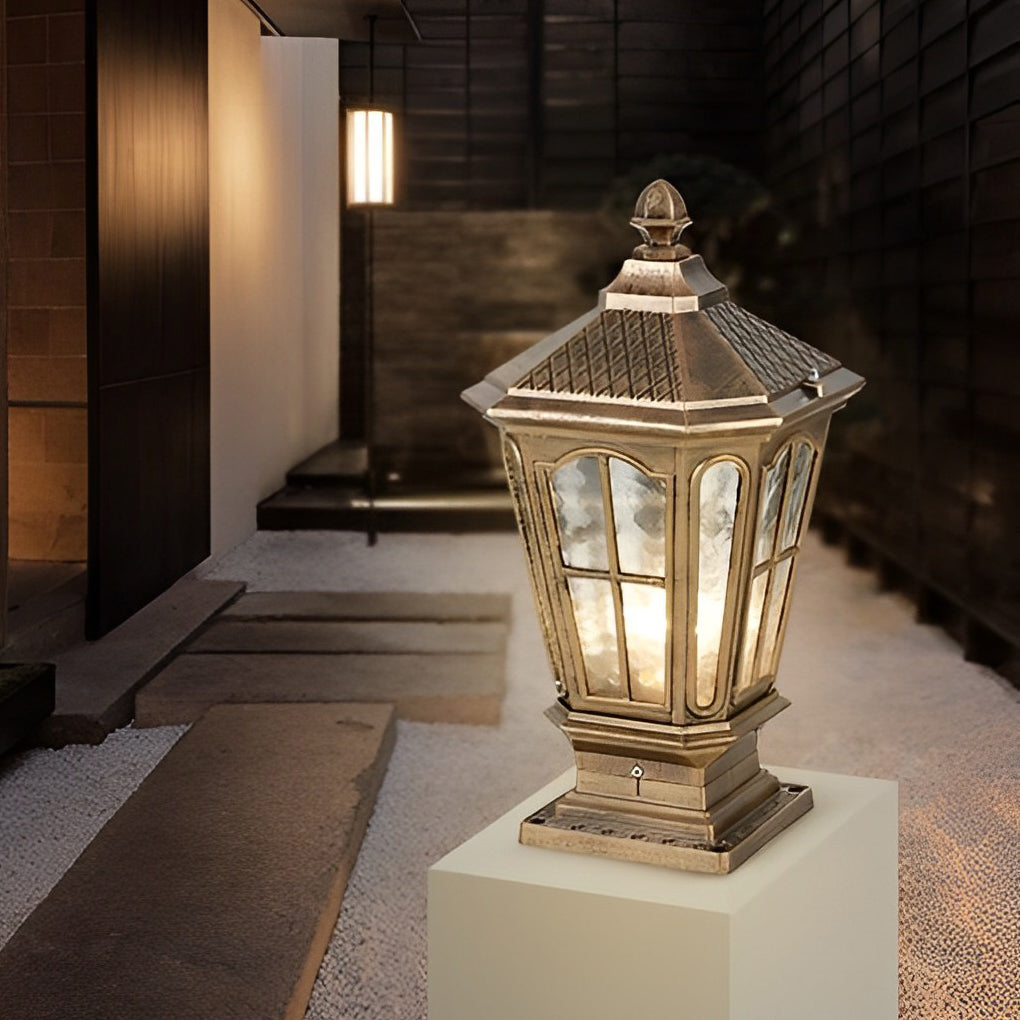 Bronze stone pillar light fixture with lantern shape installed near outdoor steps and modern building exterior.