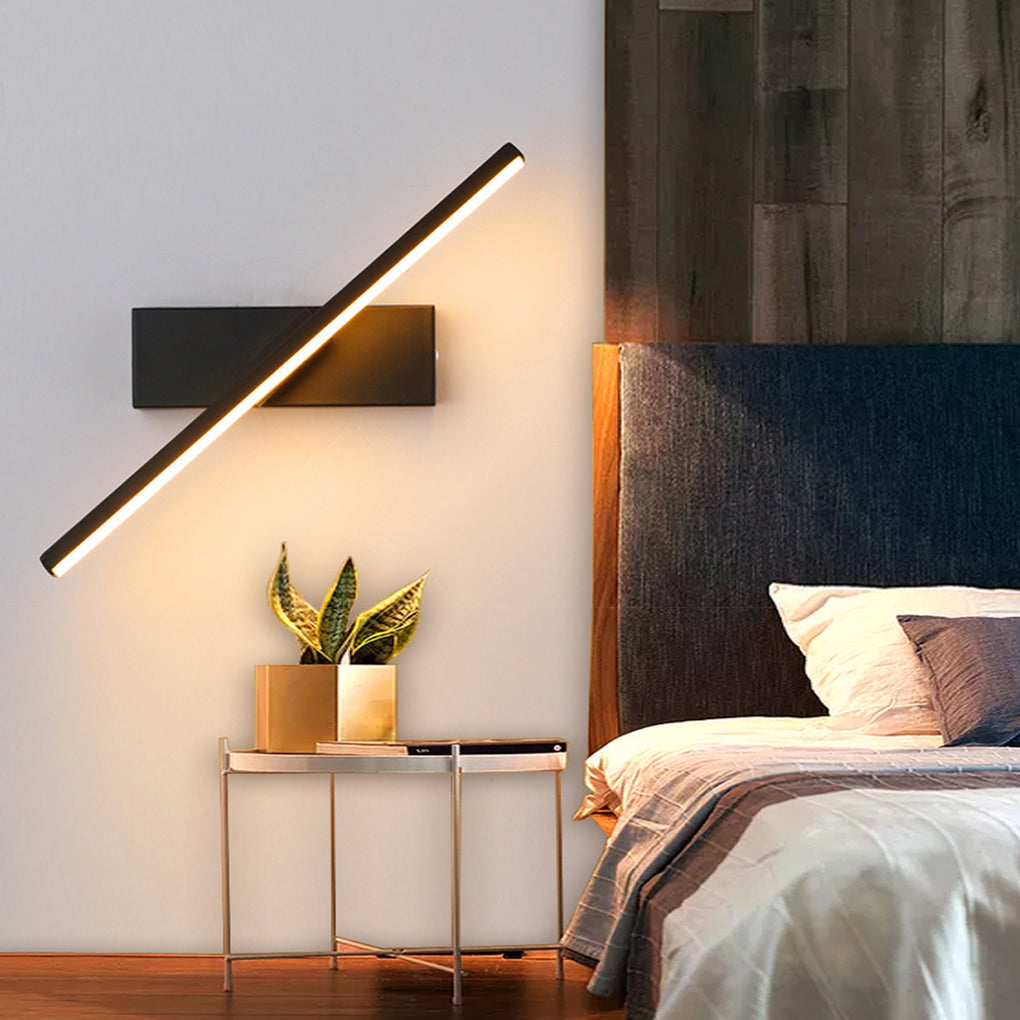 Stylish swivel wall light with a black frame, illuminating a cozy corner with a bed and floral decorations.
