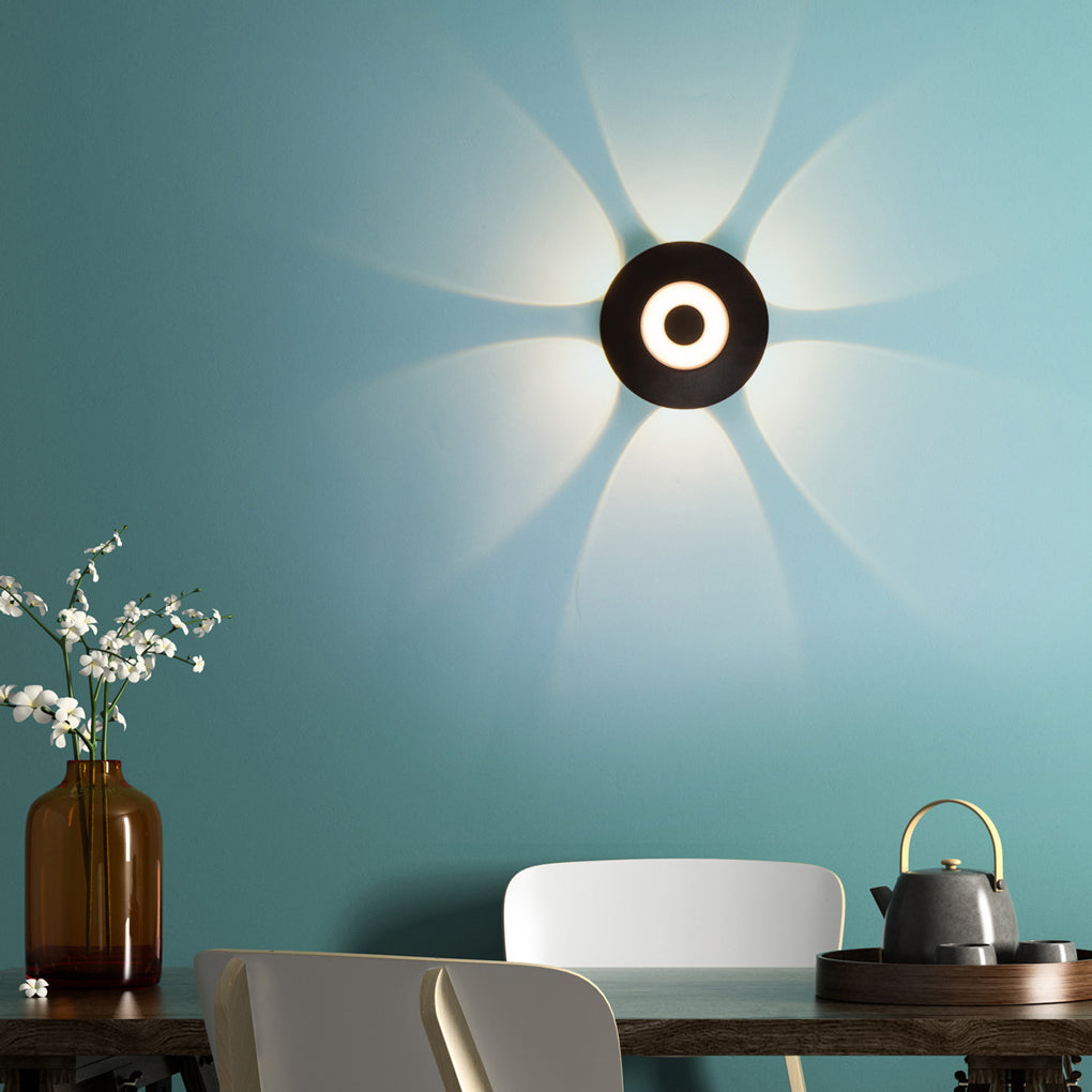 Sunflower LED wall light casting a gentle, radiant glow on a textured wall.