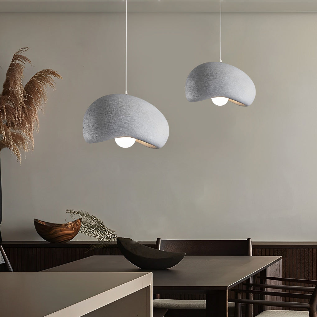 Three resin pendant lights with a sleek, textured finish hanging above a contemporary dining table.
