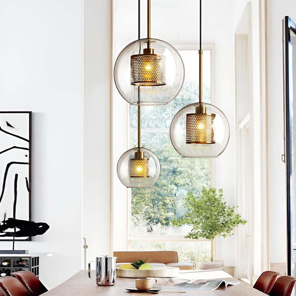 Trio of Clear Glass Globe Pendant spheres at staggered heights in a bright modern dining room.