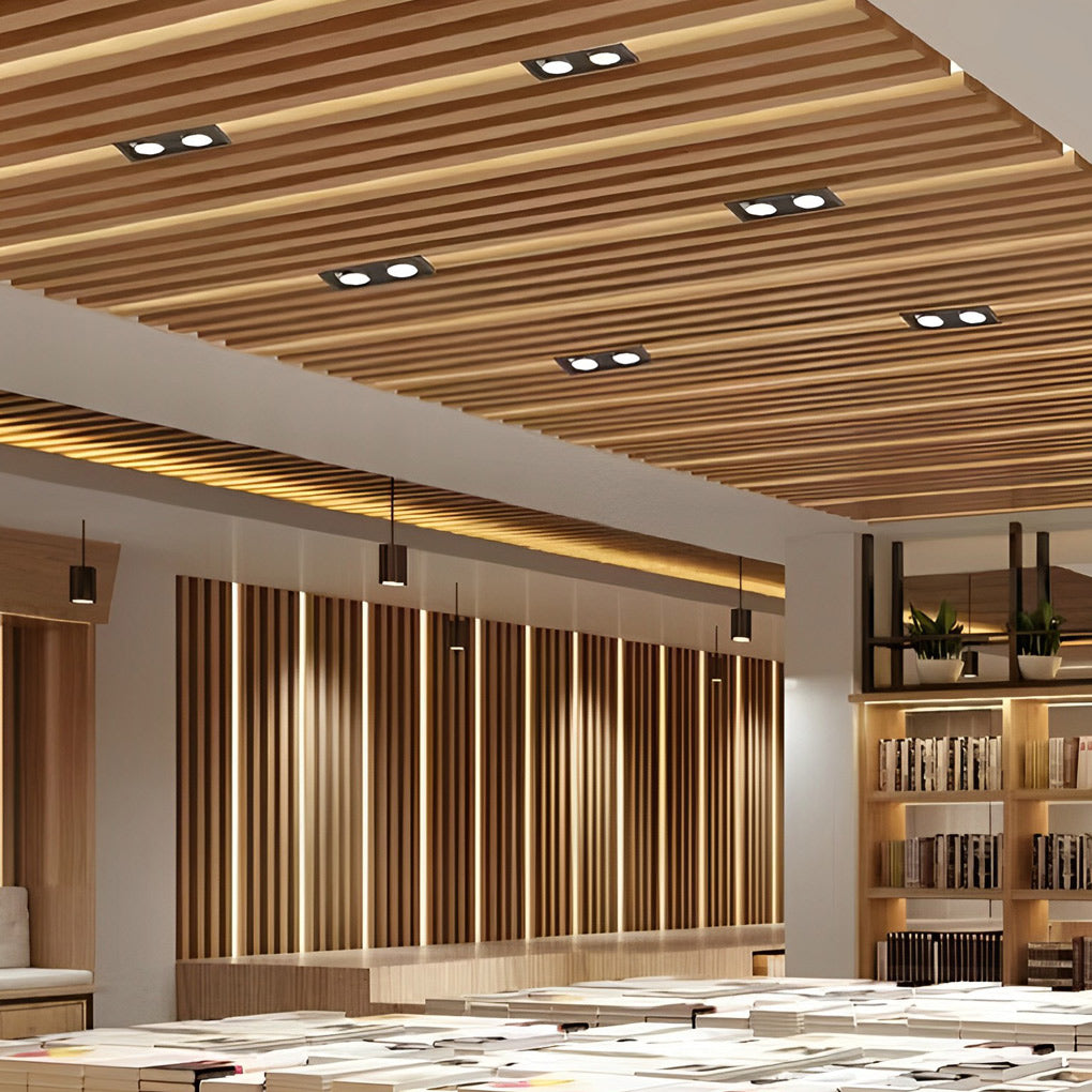 Twin recessed spotlights mounted in wooden ceiling for warm commercial interior lighting.