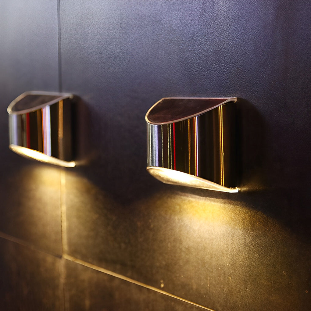 Two stainless steel wall lamps installed side by side, providing symmetrical lighting on a wall.
