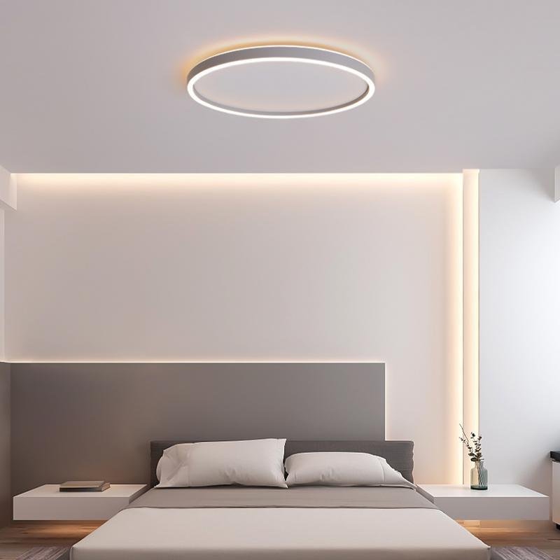 Ultra thin LED ceiling light with warm backlighting in a minimalist bedroom.