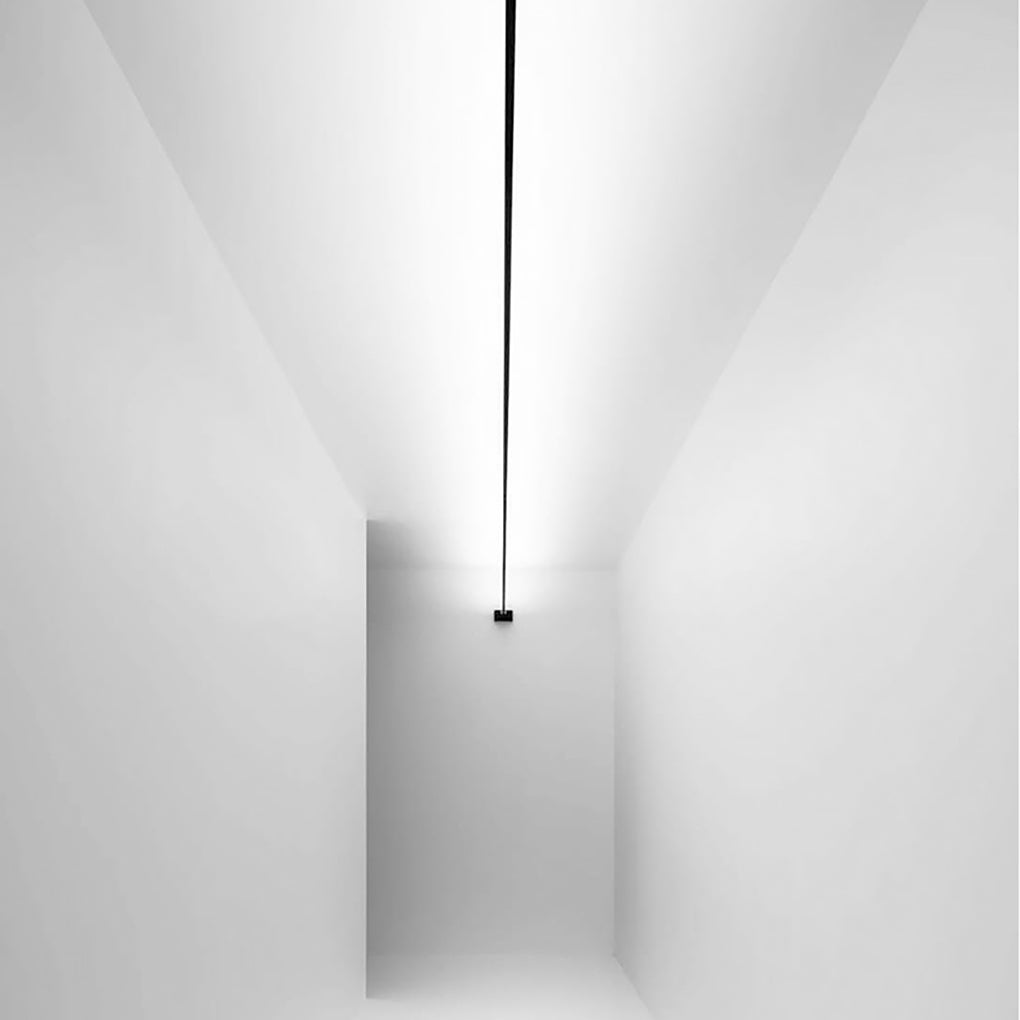 A single unlit black led lights strips for room running straight across a bright white hallway.