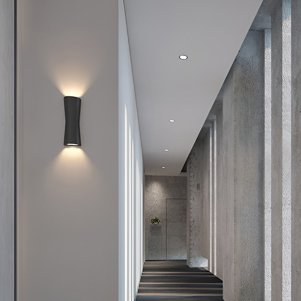 Up and down exterior wall lights mounted beside arched windows on a modern building exterior.