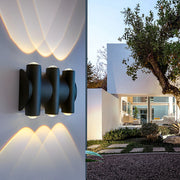 Up and down light wall sconce providing soft illumination along a stylish outdoor pathway.