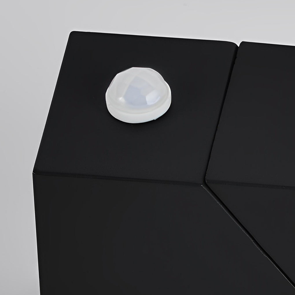 Up down sconce outdoor light with geometric design casting warm light on patio for evening relaxation.