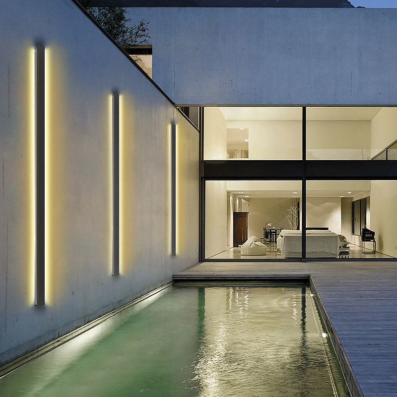 Long black outdoor lights with vertical LED strips, installed on a wooden exterior for contemporary outdoor lighting.