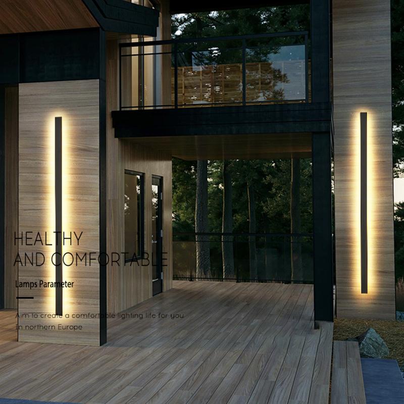 Long outdoor wall lights with vertical LED strips, enhancing modern building entrance with warm light.