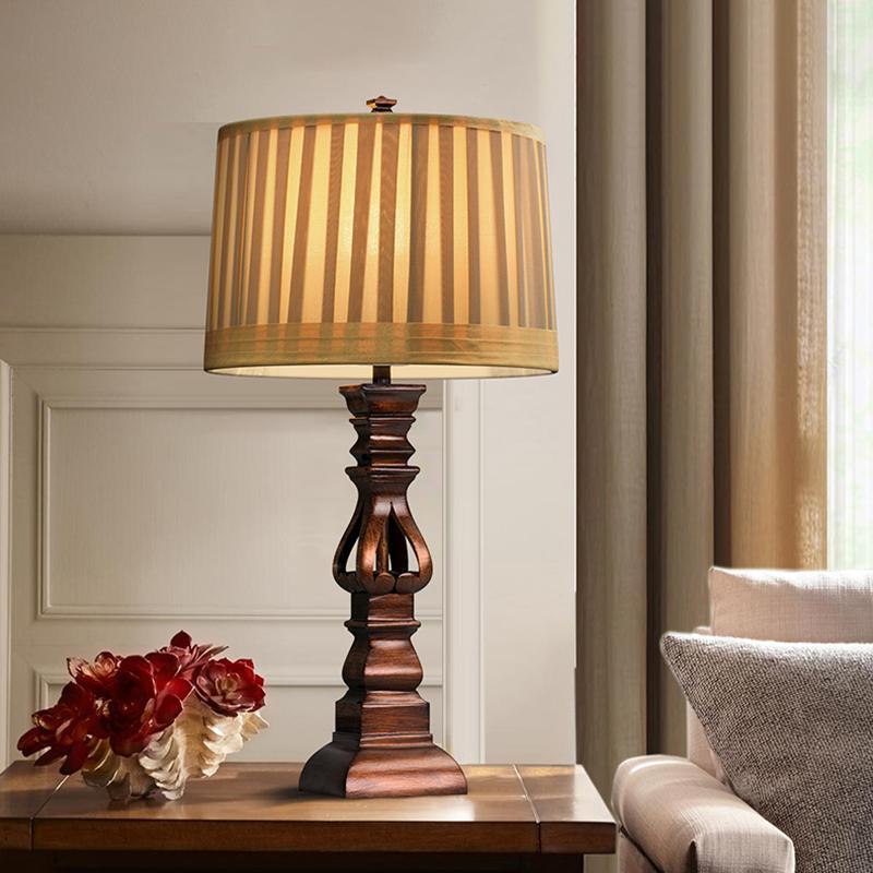 Vintage wood table lamp with a beige shade, enhancing a classic bedroom interior.