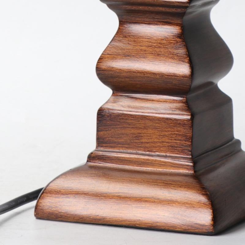 Vintage wood table lamp with a beige shade, providing soft illumination in a classic room.