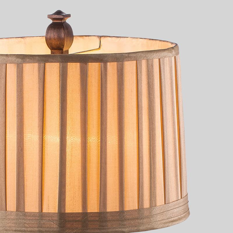 Vintage wood table lamp with a striped shade, placed on a bedside table.