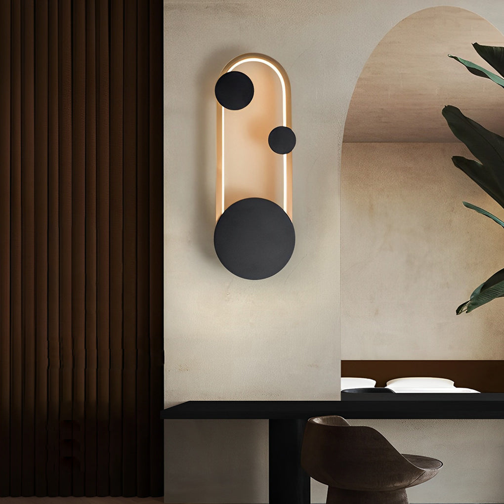 Wall mounted nightstand lights in a vertical arched form with warm illumination, styled beside a minimalist bedroom wall panel.