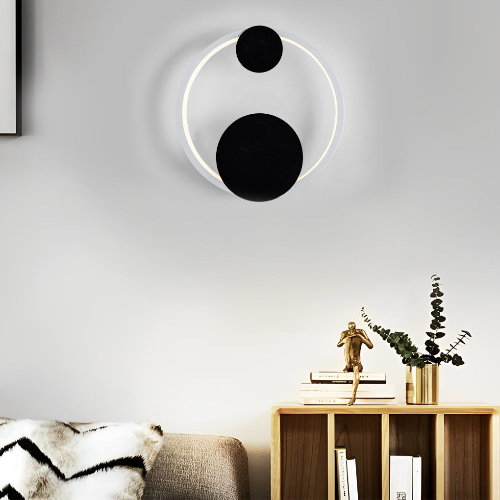 Wall mounted nightstand lights with circular halo lighting above a compact bedside cabinet in a contemporary interior.