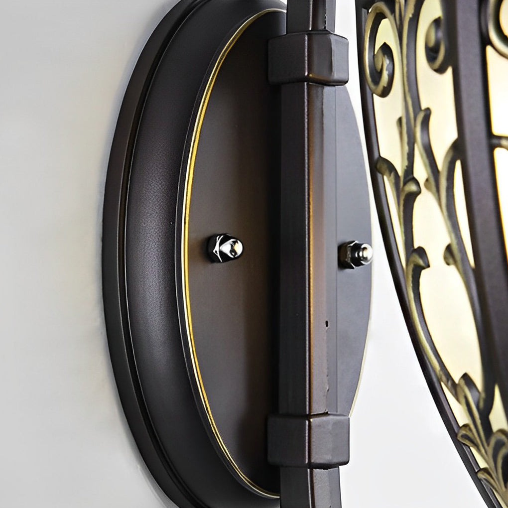 Wall sconce lantern with a decorative bronze finish, mounted on a textured wall.