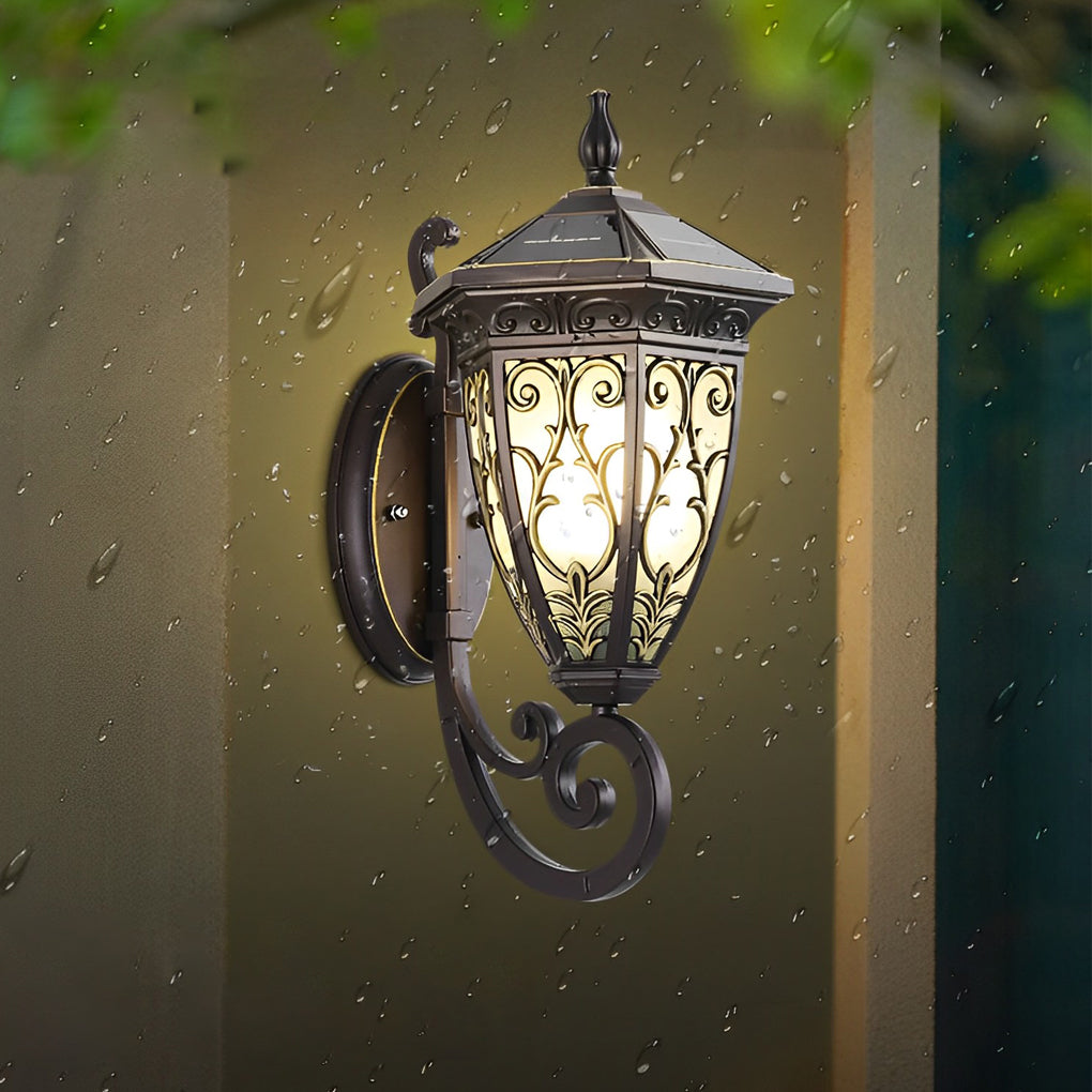 Wall sconce lantern with a close-up of its ornate glass panels and bronze frame.