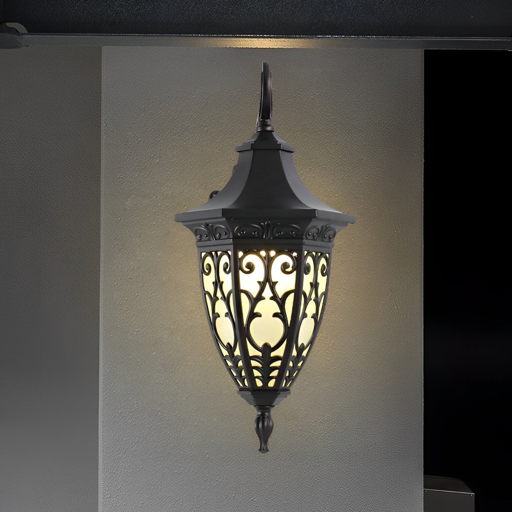 Wall sconce lantern with a traditional style, illuminating a front porch at night.