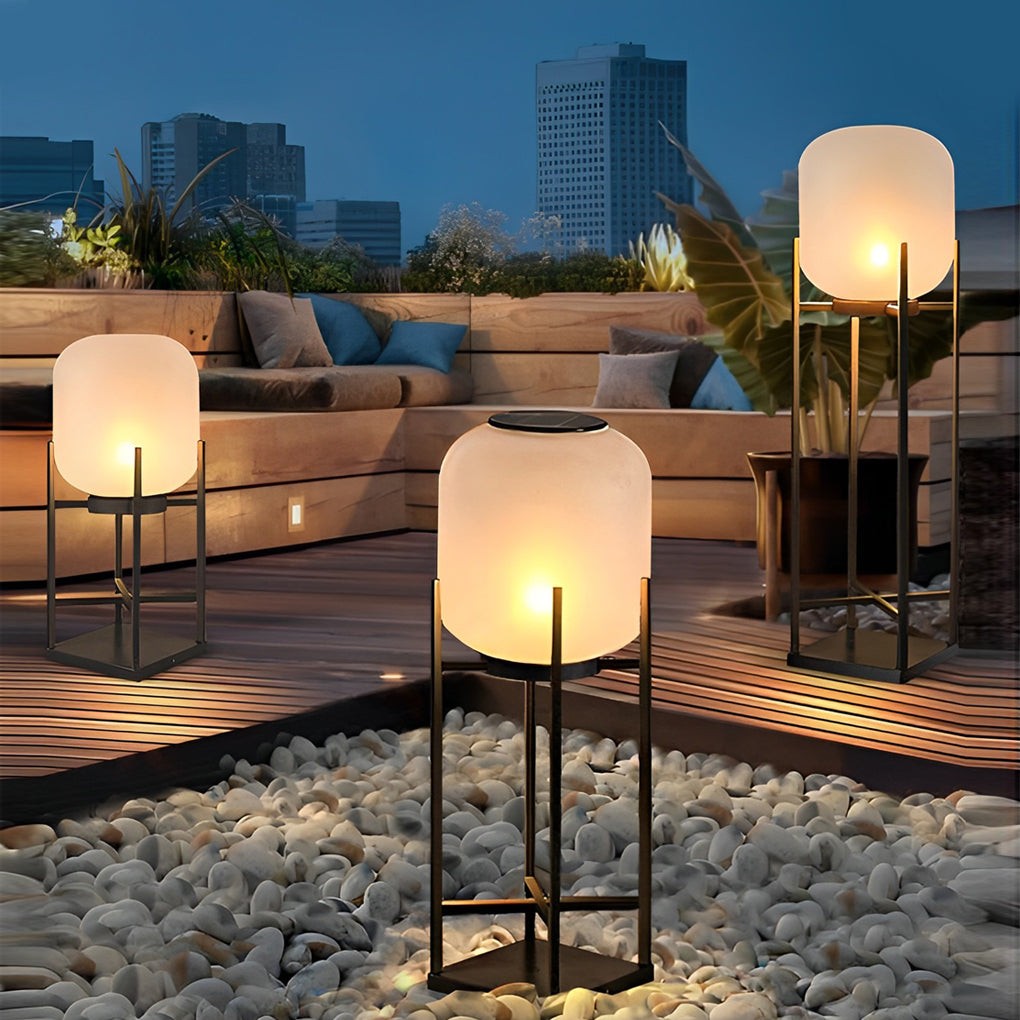 Outdoor standing light with frosted shade creating warm ambiance in garden seating area.