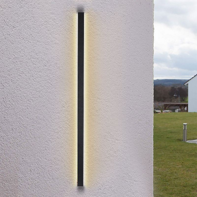 Long black outdoor lights with warm LED glow, mounted on a textured wall for contemporary outdoor ambiance.