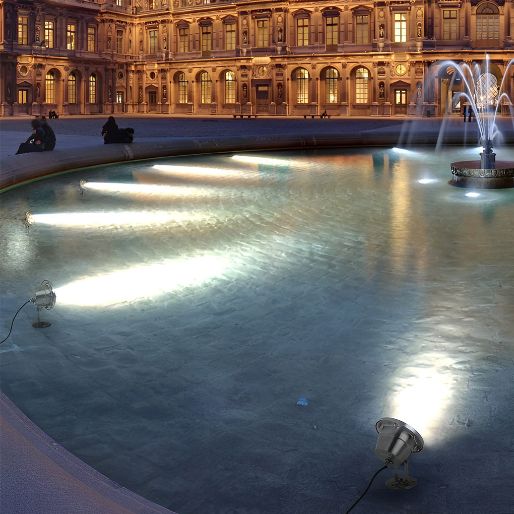 Waterproof outdoor spotlights casting light on a historic building facade and water fountain in the foreground.