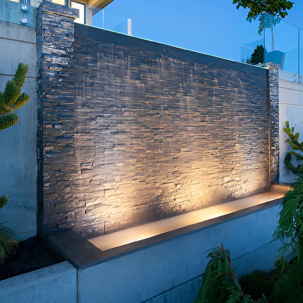 Waterproof outdoor spotlights enhancing a modern pool area with stone features and ambient lighting.