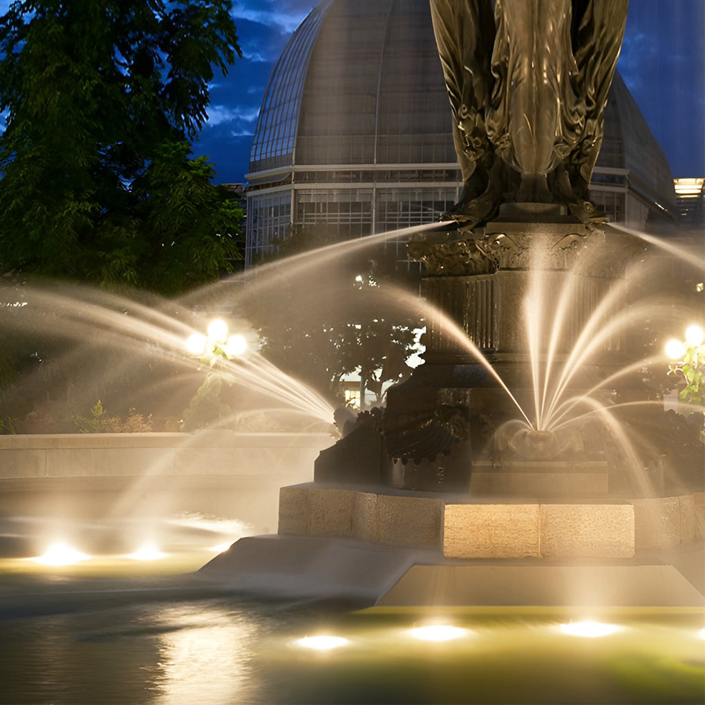 Waterproof outdoor spotlights highlighting a water fountain and stone structure in a landscaped garden.