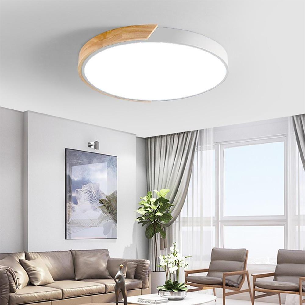 The white nordic wooden ceiling light glowing brightly in a modern living room setting here ok.