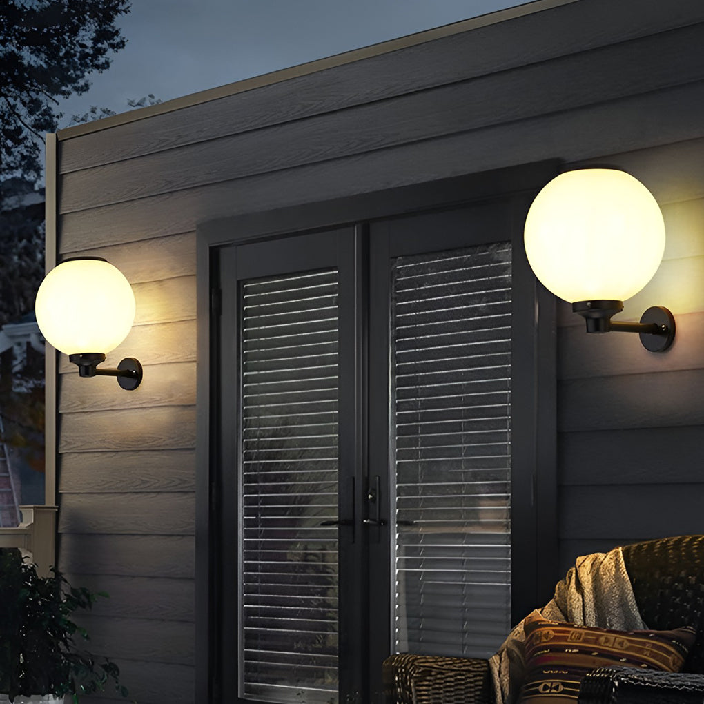 White outdoor globe wall sconce enhancing a modern outdoor deck with warm light.