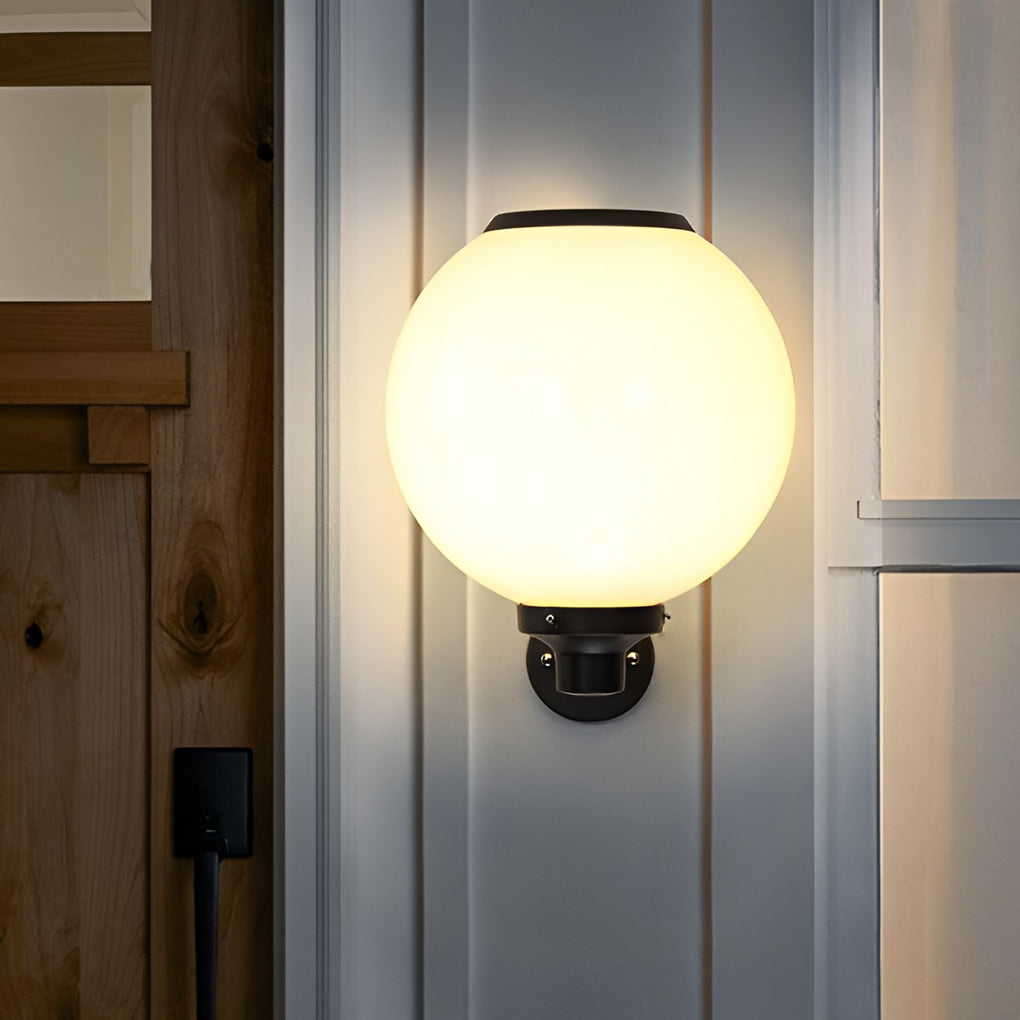 White outdoor globe wall sconce with detailed view of its solar panel and structure.