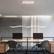 White wave pendant light with a sleek design, installed above a modern office desk.