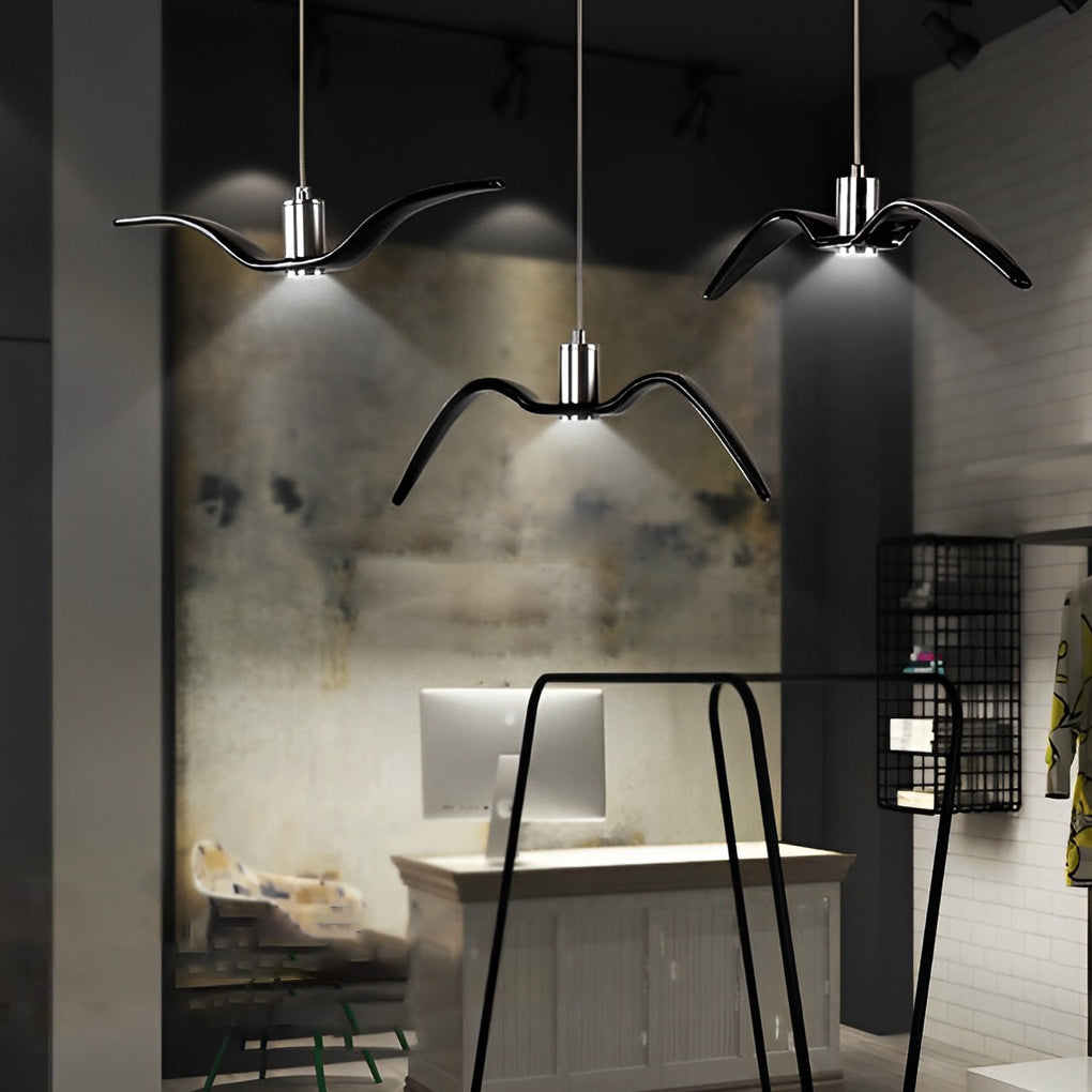 Trio of wing pendant lights hanging in an industrial-style interior.