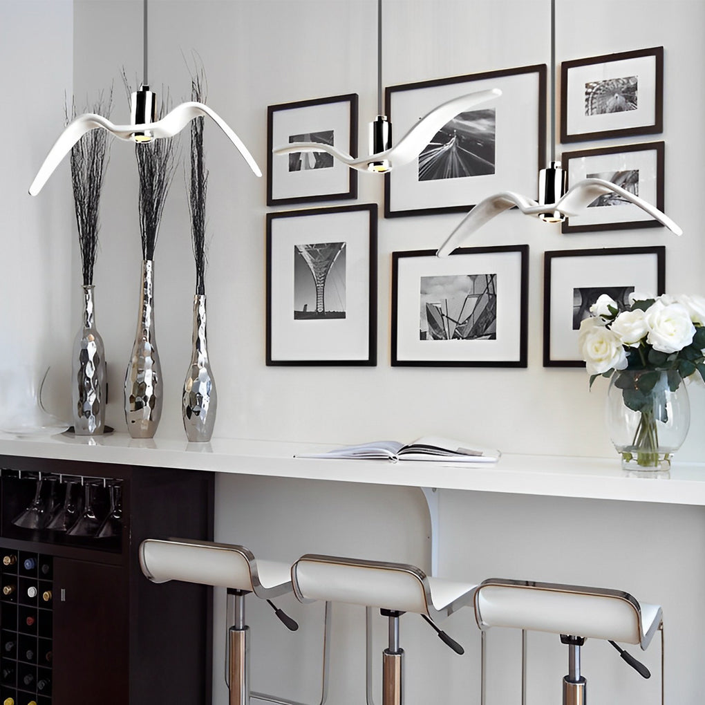 Wing pendant light installation above a kitchen island with bar stools.