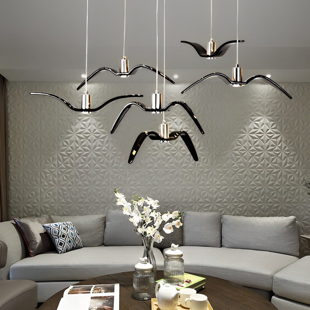 Multiple wing pendant lights arranged above a sectional sofa in a living room.
