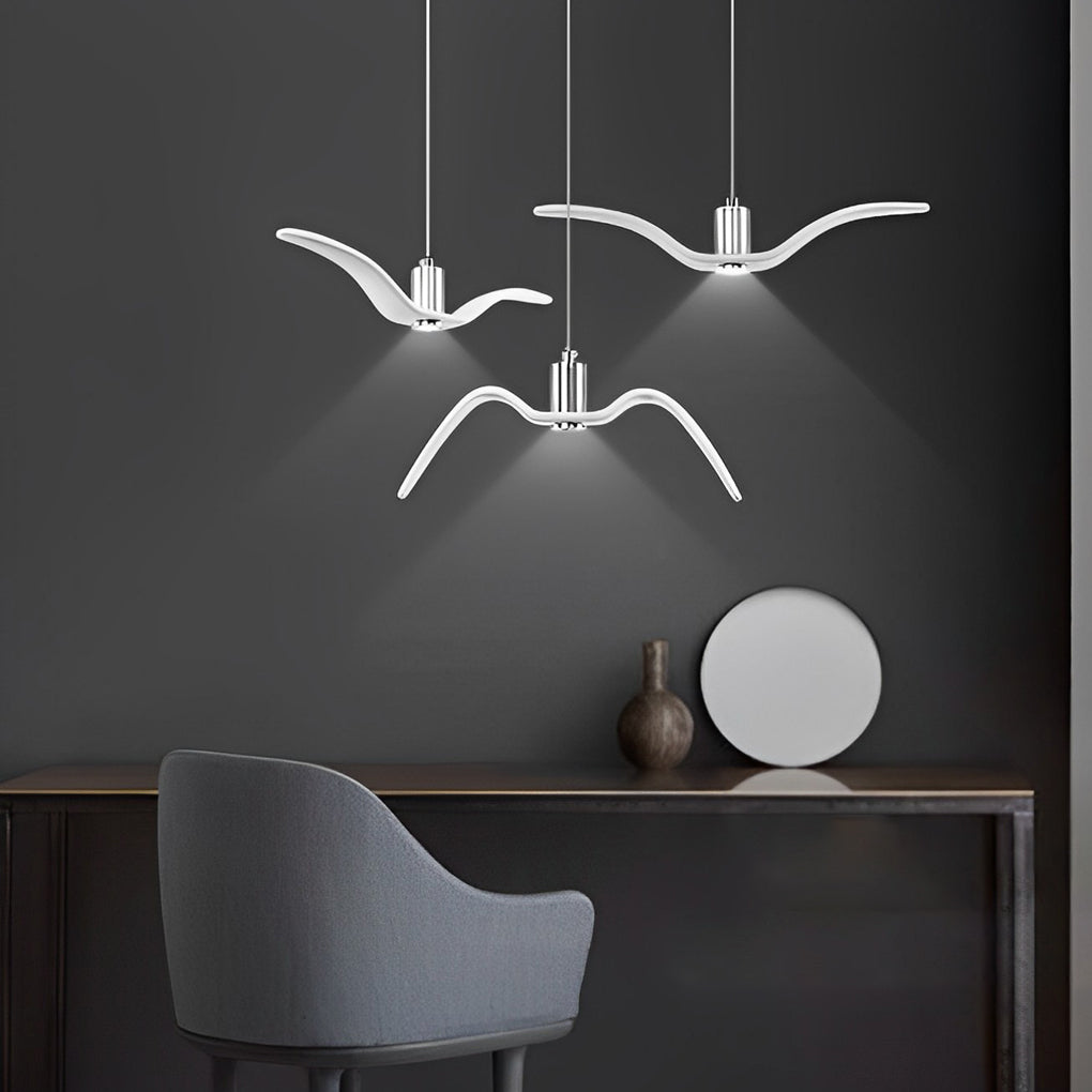 Wing pendant light mounted above a side table in a modern living space.