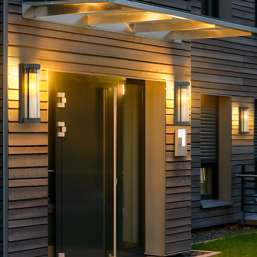 Wooden house facade showcasing a warm amber glow from sleek outdoor wall mount lights flanking the modern front door.