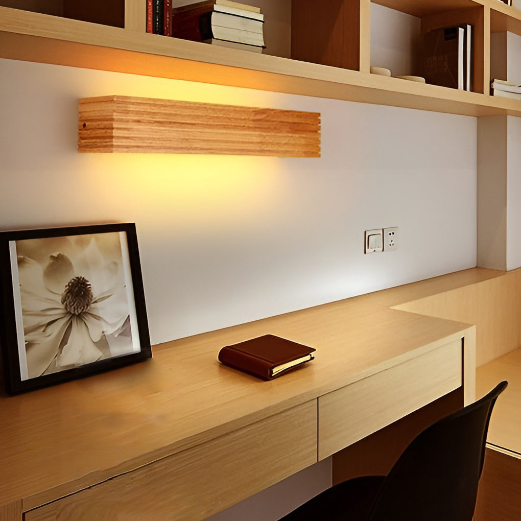 Wooden wall lamp installed above a floating shelf, enhancing decorative display lighting in a home office.